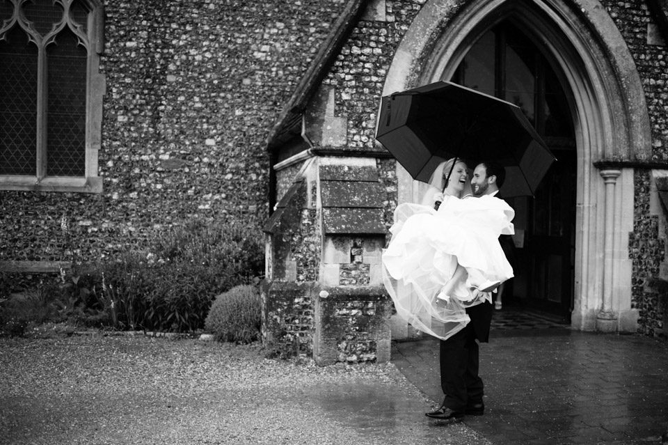 Wedding Photographer in Berkshire of the Bride and Groom leaving the church in the rain 